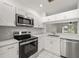 Well-lit, upgraded kitchen with modern stainless steel appliances, white cabinetry, and bright countertops at 8612 Hunters Key Cir, Tampa, FL 33647