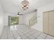 Bright living room with white tile flooring, chandelier, and sliding glass doors to a screened lanai at 8612 Hunters Key Cir, Tampa, FL 33647