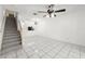 Open-concept living area with stairway, white tile flooring, and eat-in kitchen view at 8612 Hunters Key Cir, Tampa, FL 33647