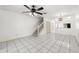 Spacious living area with tiled flooring, modern lighting fixtures, and staircase leading to upper level at 8612 Hunters Key Cir, Tampa, FL 33647