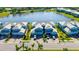 Aerial view of blue townhomes with well-manicured lawns and a serene lake in a beautiful community at 915 Tidewater Shores Loop, Bradenton, FL 34208