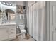 Well-lit bathroom featuring a vanity with marble countertops, round mirror and a shower with a white shower curtain at 915 Tidewater Shores Loop, Bradenton, FL 34208