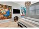 Bright bedroom featuring modern lighting fixtures, large artwork, and a comfortable bed by a window with blinds at 915 Tidewater Shores Loop, Bradenton, FL 34208