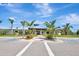 Beautiful community clubhouse surrounded by palm trees, colorful plants, and ample parking at 915 Tidewater Shores Loop, Bradenton, FL 34208