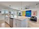 Open kitchen with stainless steel appliances, center island, and adjacent living area filled with colorful artwork at 915 Tidewater Shores Loop, Bradenton, FL 34208