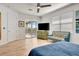 Bright main bedroom features a ceiling fan, balcony access, and a sitting area with a stylish blue couch at 915 Tidewater Shores Loop, Bradenton, FL 34208