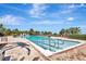 Resort-style swimming pool offers relaxation with ample lounge chairs and beautiful palm tree surroundings at 915 Tidewater Shores Loop, Bradenton, FL 34208