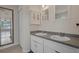 Bright bathroom featuring a double vanity with stylish white cabinetry, gray countertop, and decorative mirror reflecting the sunroom at 10101 Langan St, Spring Hill, FL 34608