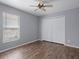 Bright bedroom with hardwood floors, ceiling fan, and a closet with double doors at 10101 Langan St, Spring Hill, FL 34608