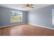 Bedroom featuring hardwood floors, a ceiling fan and a large window at 10101 Langan St, Spring Hill, FL 34608