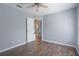 Bedroom with hardwood floors, ceiling fan, and an open door at 10101 Langan St, Spring Hill, FL 34608