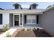 Charming front entrance featuring dormer windows, a porch, and landscaped yard at 10101 Langan St, Spring Hill, FL 34608