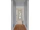 Hallway with hardwood floors, white walls and door frames, with a mirror at the end at 10101 Langan St, Spring Hill, FL 34608