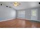 Bright living room boasts wood floors, ceiling fan, and entry door with decorative window at 10101 Langan St, Spring Hill, FL 34608