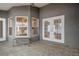 Covered patio area with gray textured walls, a wooden bench, tile floors, and double French doors at 10101 Langan St, Spring Hill, FL 34608