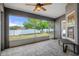 Enclosed porch with tiled floors, ceiling fan, and view of the backyard and fence at 10101 Langan St, Spring Hill, FL 34608