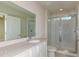 Bathroom featuring dual sinks, a large mirror, and a glass-enclosed shower creating a spa-like retreat at 10516 Hidden Banks Gln, Parrish, FL 34219