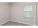 Bedroom featuring neutral walls, plush carpet, and a bright window with blinds, showcasing simple elegance at 10516 Hidden Banks Gln, Parrish, FL 34219