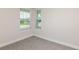Neutral-toned bedroom featuring plush carpet and two bright windows with blinds, offering simple elegance and comfort at 10516 Hidden Banks Gln, Parrish, FL 34219