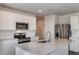 Modern kitchen featuring stainless steel appliances, white cabinetry, and a center island with countertop space at 10516 Hidden Banks Gln, Parrish, FL 34219