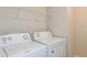 Laundry room with white washer and dryer, complemented by wire shelving for organized storage solutions at 10516 Hidden Banks Gln, Parrish, FL 34219