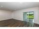Bright living room featuring dark wood floors, sliding glass doors to the outside, and neutral walls at 10516 Hidden Banks Gln, Parrish, FL 34219