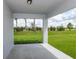 Covered patio offers a view of the green lawn and surrounding greenery, enhancing the outdoor living space at 10516 Hidden Banks Gln, Parrish, FL 34219