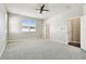 A spacious bedroom featuring a window and two entry doors, carpet and neutral paint at 10628 Massimo Dr, Wimauma, FL 33598