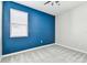 Cozy bedroom with a ceiling fan and a navy accent wall with a window at 10628 Massimo Dr, Wimauma, FL 33598