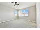 A spacious bedroom featuring two windows, plush carpeting and a ceiling fan at 10628 Massimo Dr, Wimauma, FL 33598
