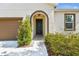 Close-up of the home's front entrance, featuring an arched entryway and manicured landscaping at 10628 Massimo Dr, Wimauma, FL 33598