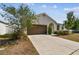 Charming single-story home featuring a spacious driveway and a beautifully landscaped front yard at 10628 Massimo Dr, Wimauma, FL 33598