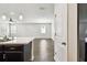 Open kitchen view with dark cabinets, light countertops, and pendant lighting into the connected living space at 10628 Massimo Dr, Wimauma, FL 33598