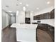 Modern kitchen featuring dark cabinetry, stainless steel appliances, and a central island with a breakfast bar at 10628 Massimo Dr, Wimauma, FL 33598