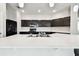 Spacious kitchen featuring dark cabinets, stainless steel appliances, and a large white countertop at 10628 Massimo Dr, Wimauma, FL 33598