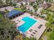 Aerial view of a community pool and picnic pavilion surrounded by several houses and palm trees at 10628 Massimo Dr, Wimauma, FL 33598