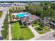 Aerial view of a community pool area surrounded by palm trees and lush landscaping in a well-maintained neighborhood at 10628 Massimo Dr, Wimauma, FL 33598