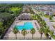 Aerial view of a community pool and adjacent picnic pavilion surrounded by several houses and palm trees at 10628 Massimo Dr, Wimauma, FL 33598