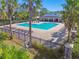 Community pool with lounge chairs surrounded by palm trees and a perimeter fence at 10628 Massimo Dr, Wimauma, FL 33598