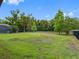 Expansive grassy backyard enclosed by a sleek black fence and mature trees, offering a private outdoor space at 1104 Isobel Reserve Ln, Tampa, FL 33613