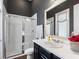 Modern bathroom with glass-enclosed shower, dark cabinets, white countertops, and neutral color scheme at 1104 Isobel Reserve Ln, Tampa, FL 33613