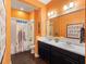 Vibrant bathroom with double vanity, bright orange walls, decorative shower curtain and dark wood floors at 1104 Isobel Reserve Ln, Tampa, FL 33613