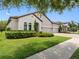 Elegant single-story home with a terracotta tile roof, three-car garage, and manicured landscaping at 1104 Isobel Reserve Ln, Tampa, FL 33613