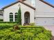 Stunning home facade with a well-manicured front yard, arched entryway, and attached garage at 1104 Isobel Reserve Ln, Tampa, FL 33613
