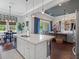 Bright kitchen with white cabinetry, large island, and open view to the dining and living areas at 1104 Isobel Reserve Ln, Tampa, FL 33613
