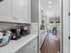 Bright kitchen featuring white cabinets and countertops with a coffee bar area and wooden floors at 1104 Isobel Reserve Ln, Tampa, FL 33613