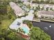 Aerial view showcasing a pool and outdoor lounge area surrounded by lush landscaping and water features, creating a resort-like feel at 11162 Kapok Grand Cir, Madeira Beach, FL 33708