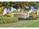 Kapok Grand property entrance sign amid lush tropical landscaping at 11162 Kapok Grand Cir, Madeira Beach, FL 33708