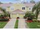 Inviting two-story townhouse showcases well-maintained landscaping and a double garage, creating a welcoming curb appeal at 11162 Kapok Grand Cir, Madeira Beach, FL 33708