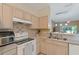 Cozy kitchen featuring wood cabinets, a ceramic backsplash, and a double stainless steel sink at 11162 Kapok Grand Cir, Madeira Beach, FL 33708